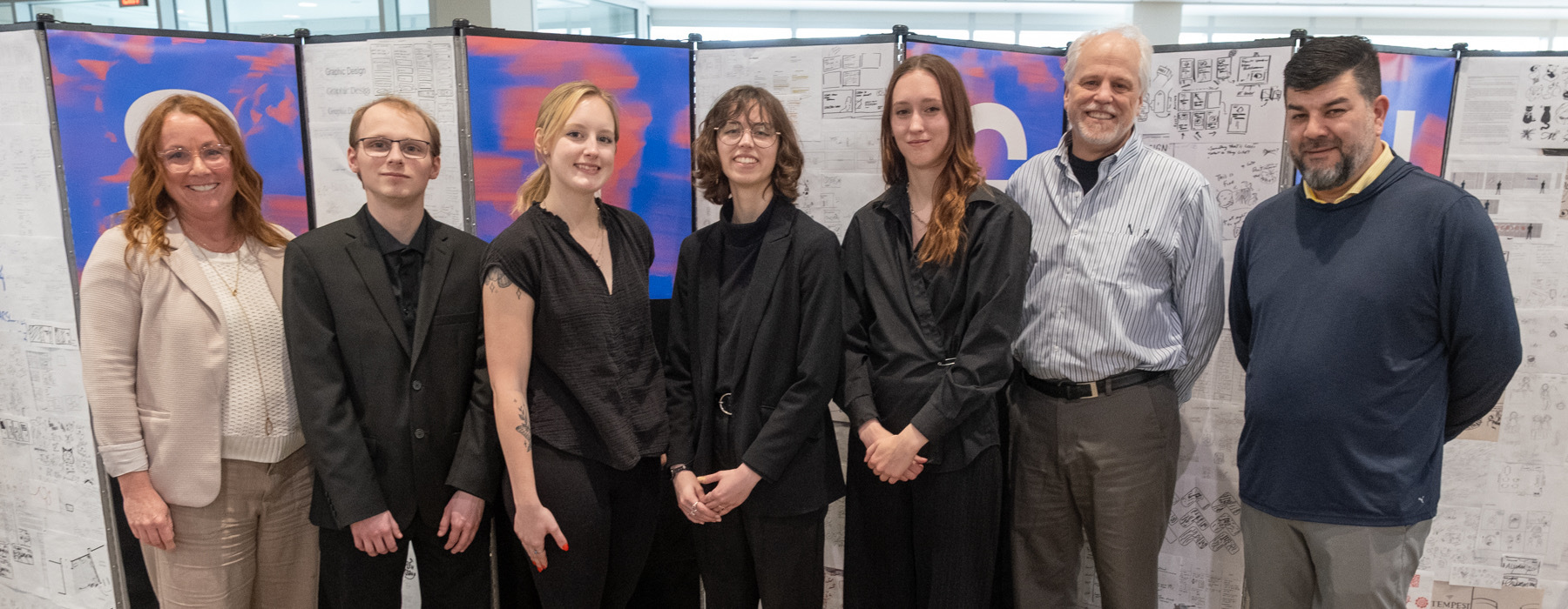 Alison Popp, Blake Flanery, Emma Eling, Hailey Nye, Abby Keown, Tim Powers, and Nic Mata posed and smilling in front of a backgrop featuring process work