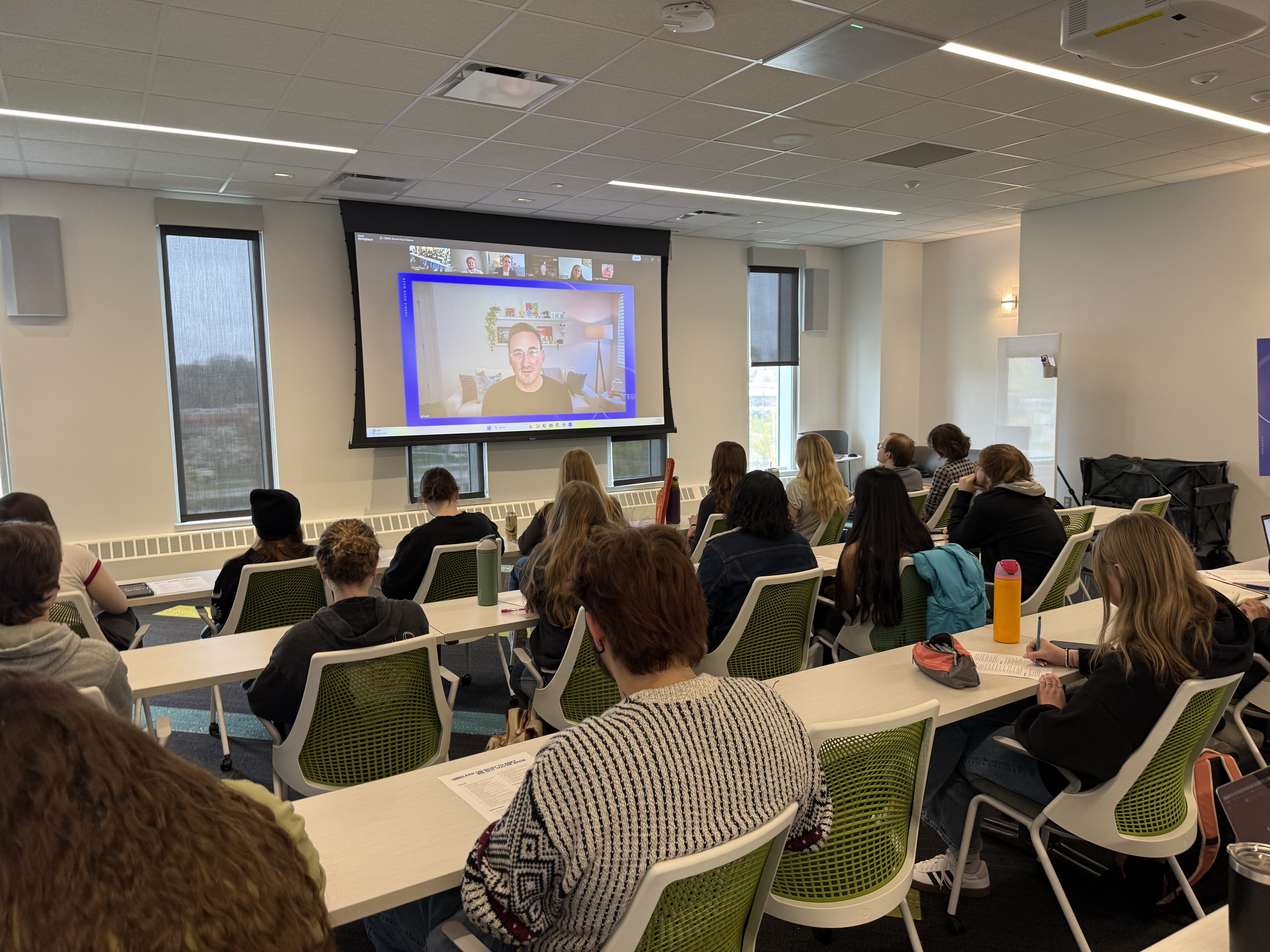 A classroom full of students looking at Kieth Fleck projected onto a screen